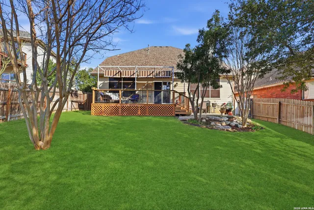 a view of a house with backyard and a tree