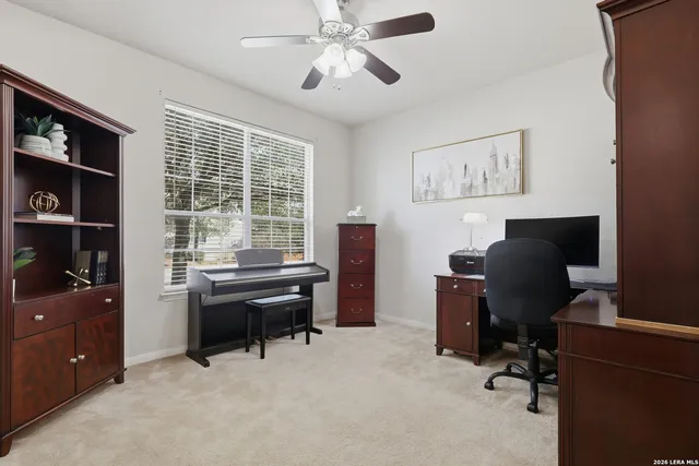a view of a workspace with furniture and a window