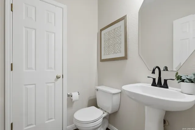 a bathroom with a toilet a sink and mirror