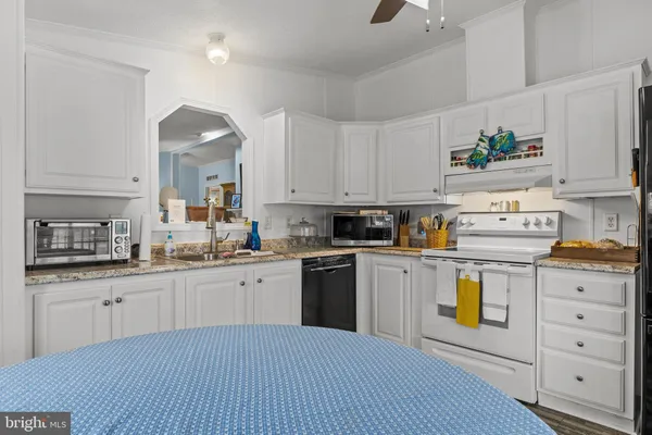 a kitchen with a dining table chairs and white appliances