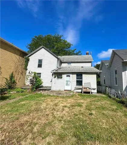 a view of a house with a big yard and large tree
