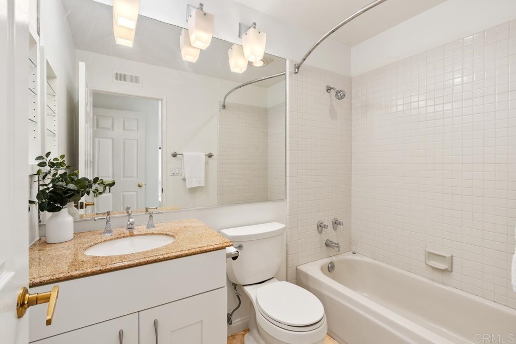 3303 Bumann Road Encinitas, CA 92024 - Photo 27 of 50 a bathroom with a granite countertop sink a toilet a mirror and shower