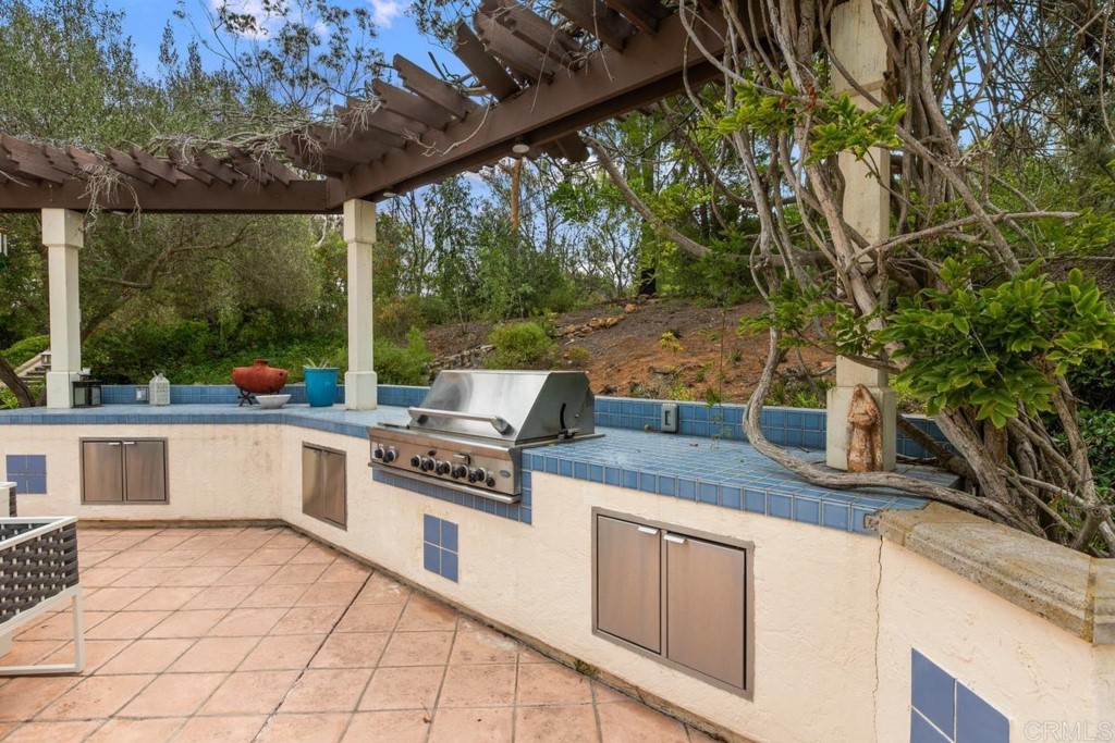 3303 Bumann Road Encinitas, CA 92024 - Photo 39 of 50 a open kitchen with stainless steel appliances granite countertop a stove a sink dishwasher and white cabinets with wooden floor