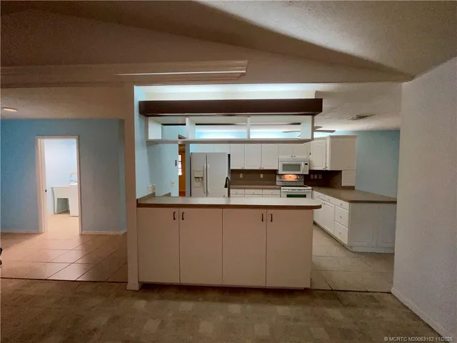 a kitchen with granite countertop a sink and cabinets