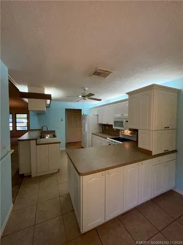 a kitchen with stainless steel appliances granite countertop a sink and a refrigerator
