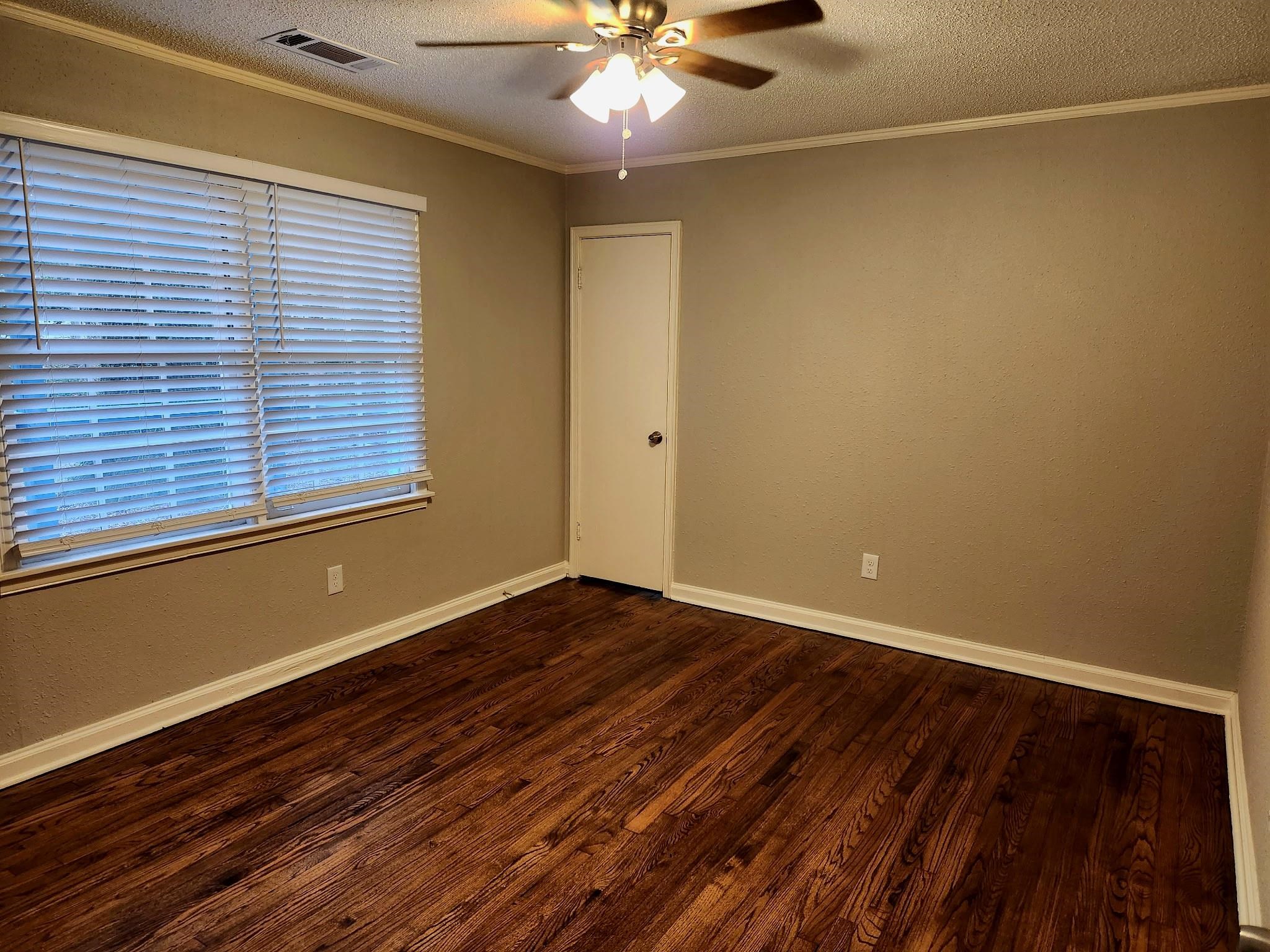 866 Colonial Road Memphis, TN 38117 - Photo 12 of 15 Spare room featuring a textured ceiling, wood finished floors, ornamental molding, ceiling fan, and a textured wall