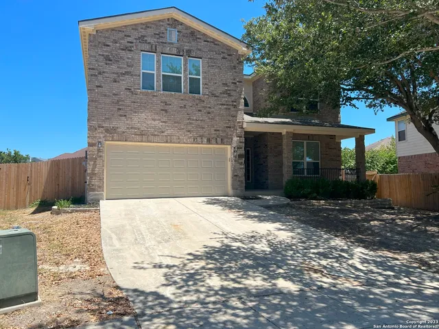 a front view of a house with a yard and a garage