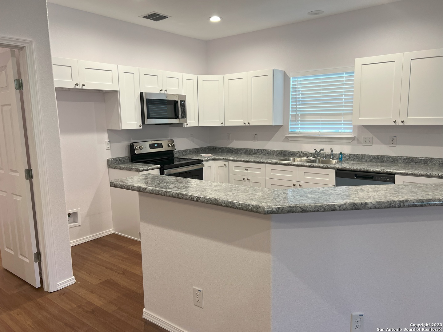 141 Wright Cove Cibolo, TX 78108 - Photo 11 of 35 a kitchen with granite countertop a sink stove and refrigerator