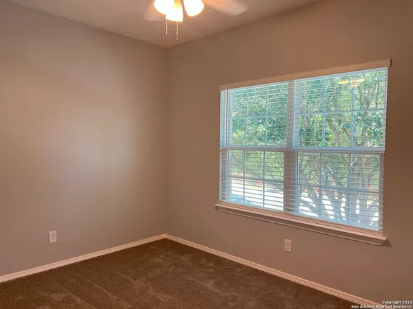 an empty room with windows and fan