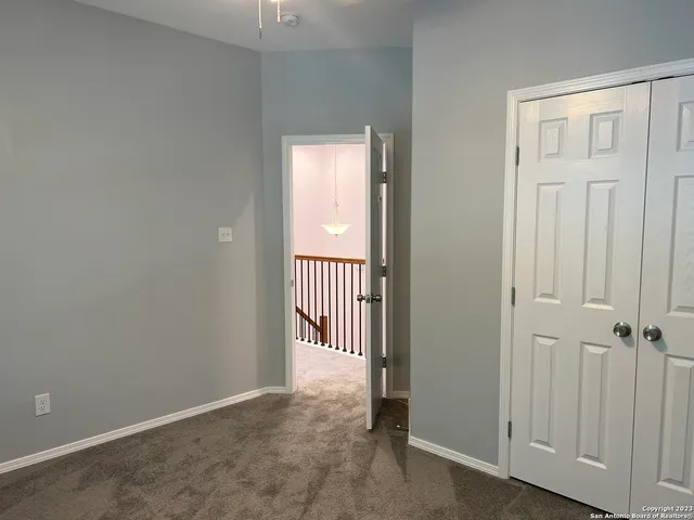 en empty room with wooden floor and chandelier fan