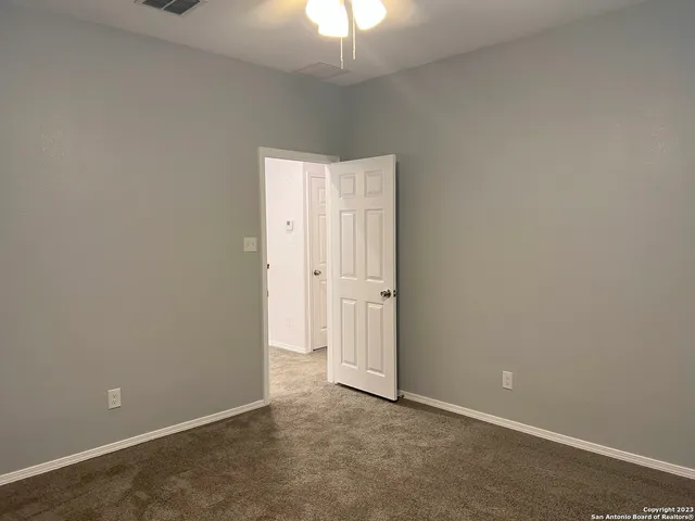 an empty room with a chandelier fan