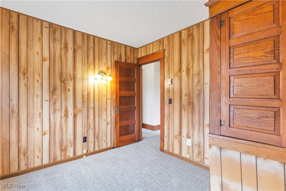 48265 Middle Ridge Road Amherst, OH 44001 - Photo 16 of 43 First bedroom upstairs with wood paneled walls, new carpeting, built in closet/cabinetry.