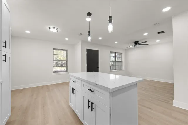 an open kitchen with a sink and chandelier