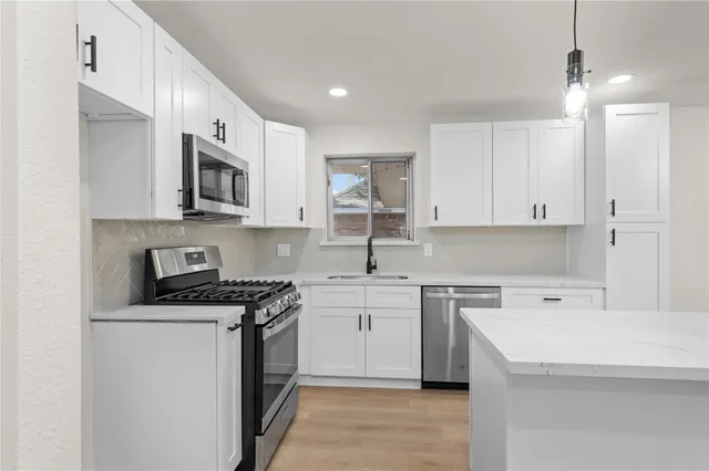 a kitchen with a sink a stove and cabinets
