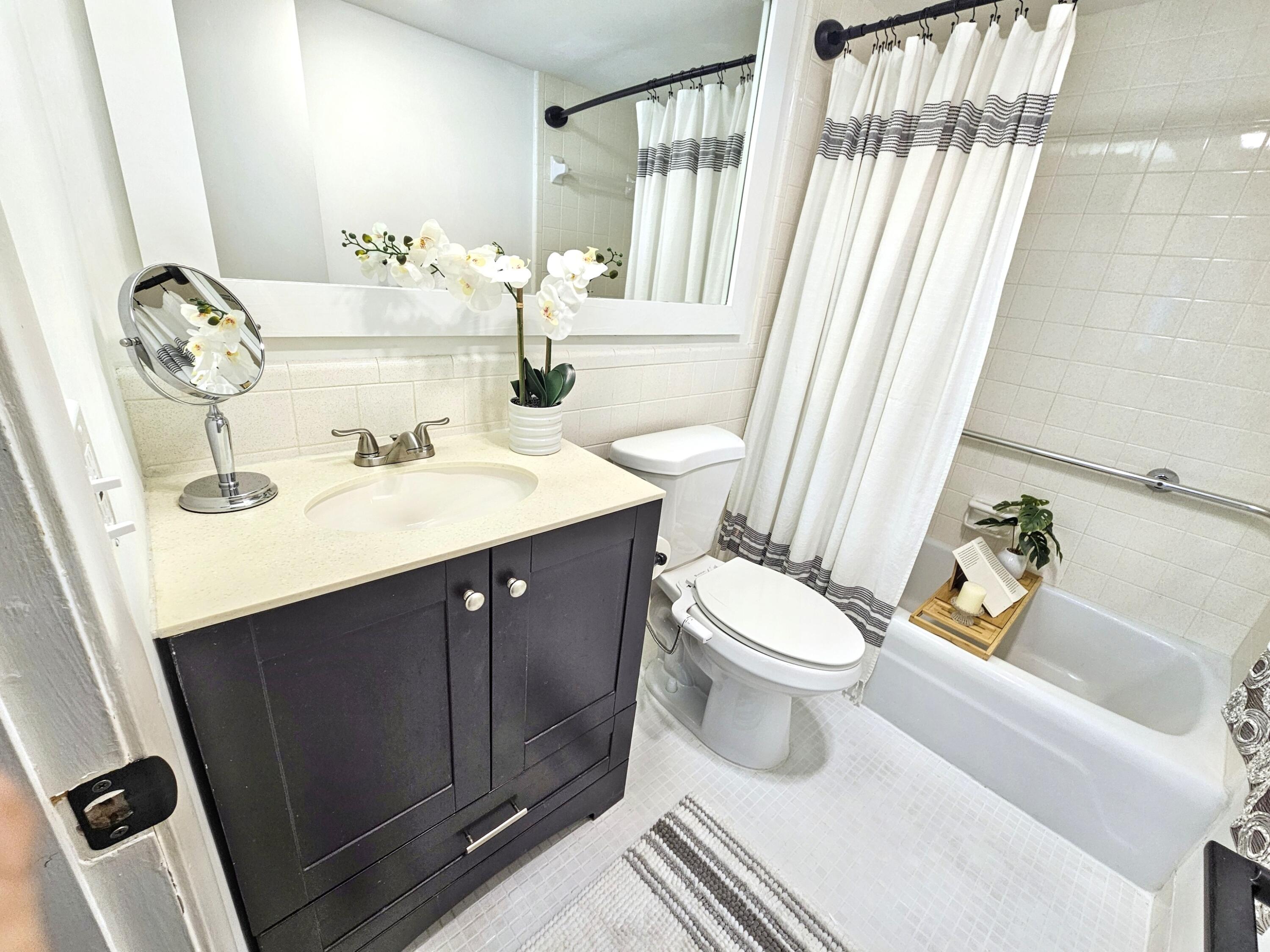 6530 North Ocean Boulevard, Unit 205 Ocean Ridge, FL 33435 - Photo 26 of 53 a bathroom with a sink a toilet and shower curtain