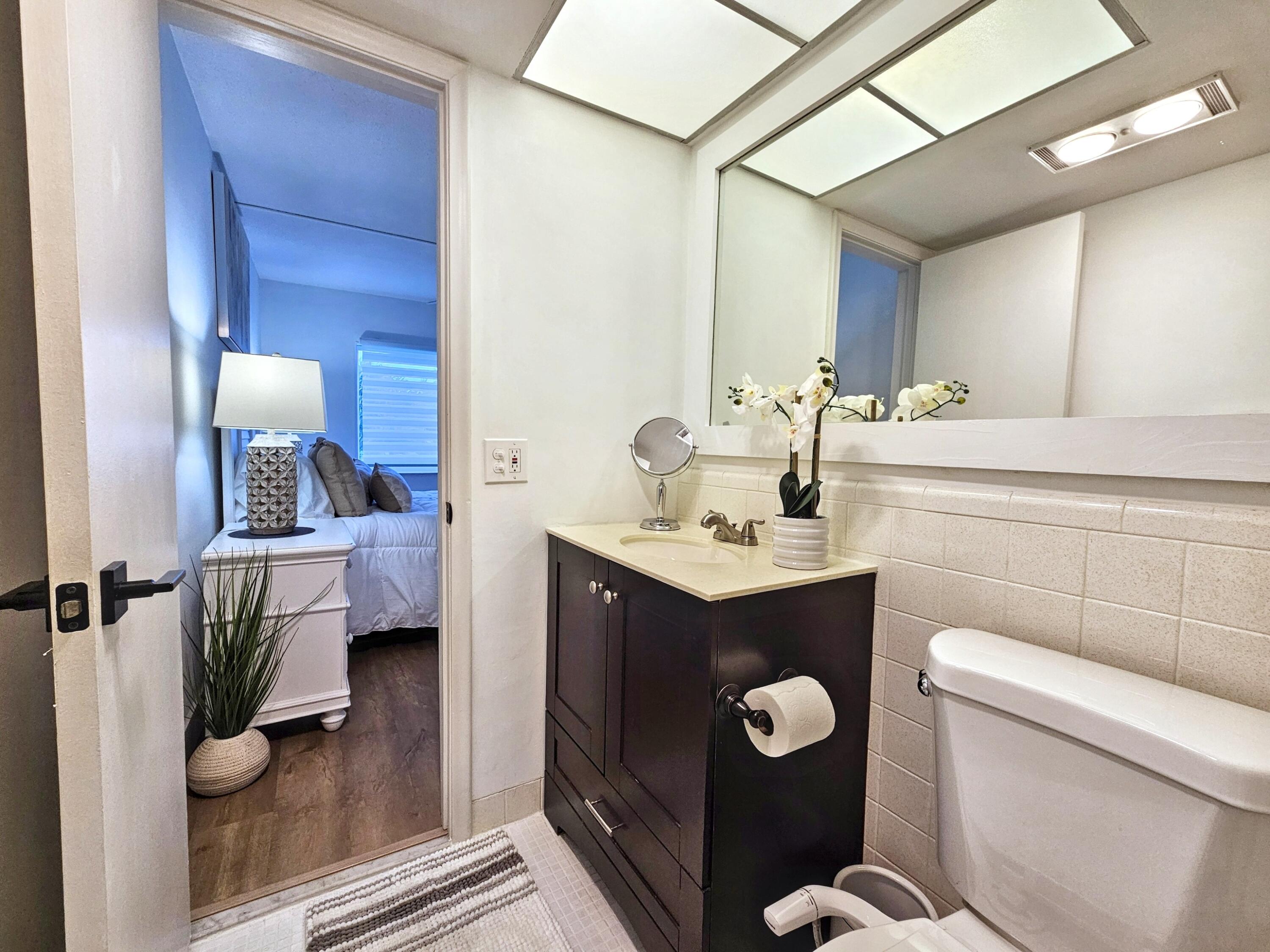 6530 North Ocean Boulevard, Unit 205 Ocean Ridge, FL 33435 - Photo 27 of 53 a bathroom with a toilet sink and mirror