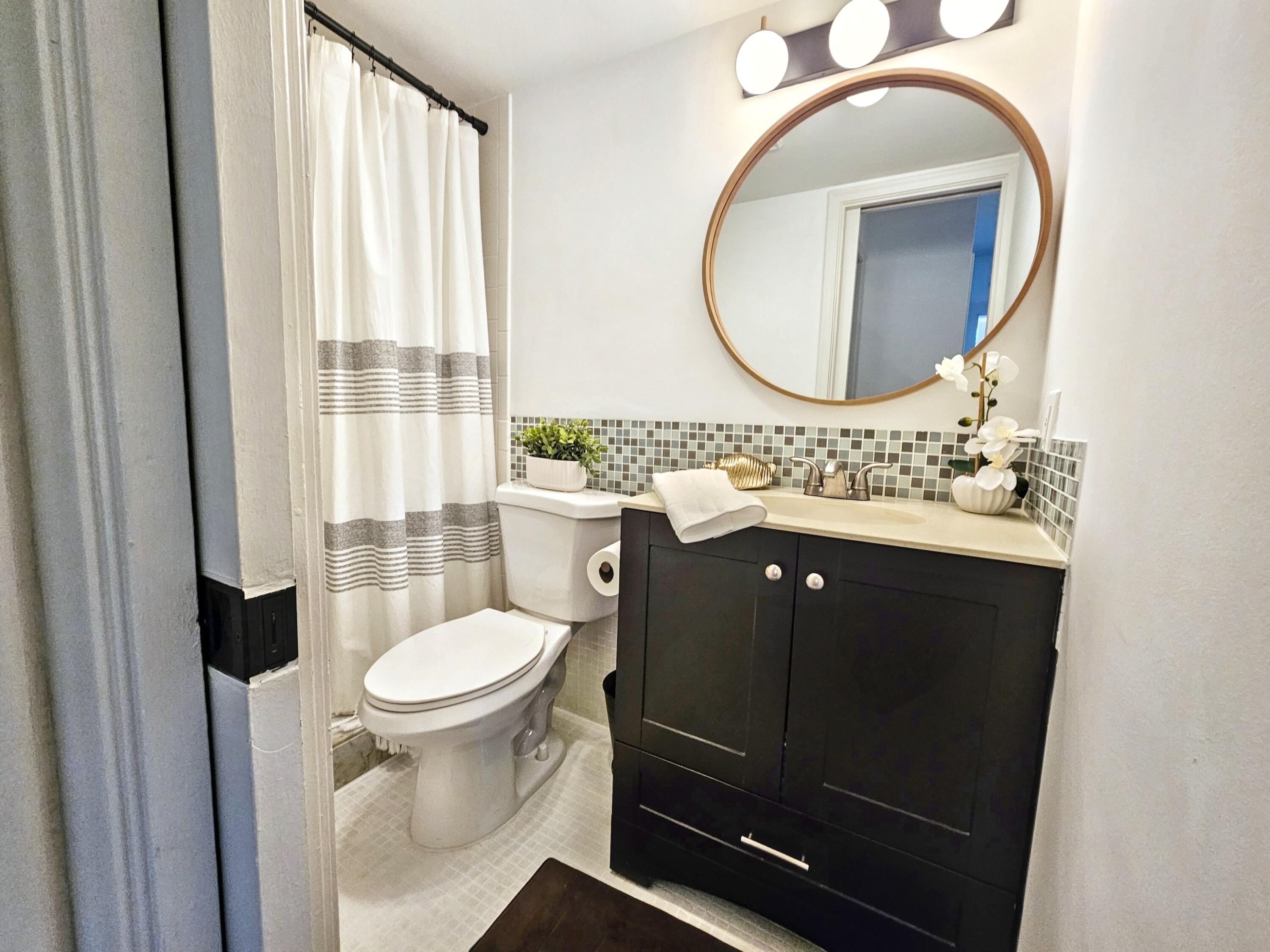 6530 North Ocean Boulevard, Unit 205 Ocean Ridge, FL 33435 - Photo 31 of 53 a bathroom with a sink a toilet and a mirror