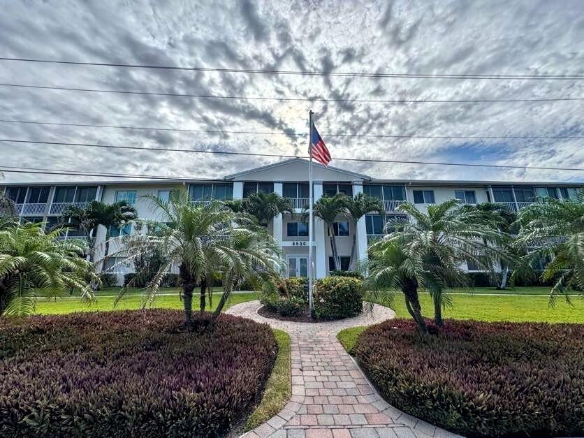 6530 North Ocean Boulevard, Unit 205 Ocean Ridge, FL 33435 - Photo 38 of 53 a front view of a house with a yard