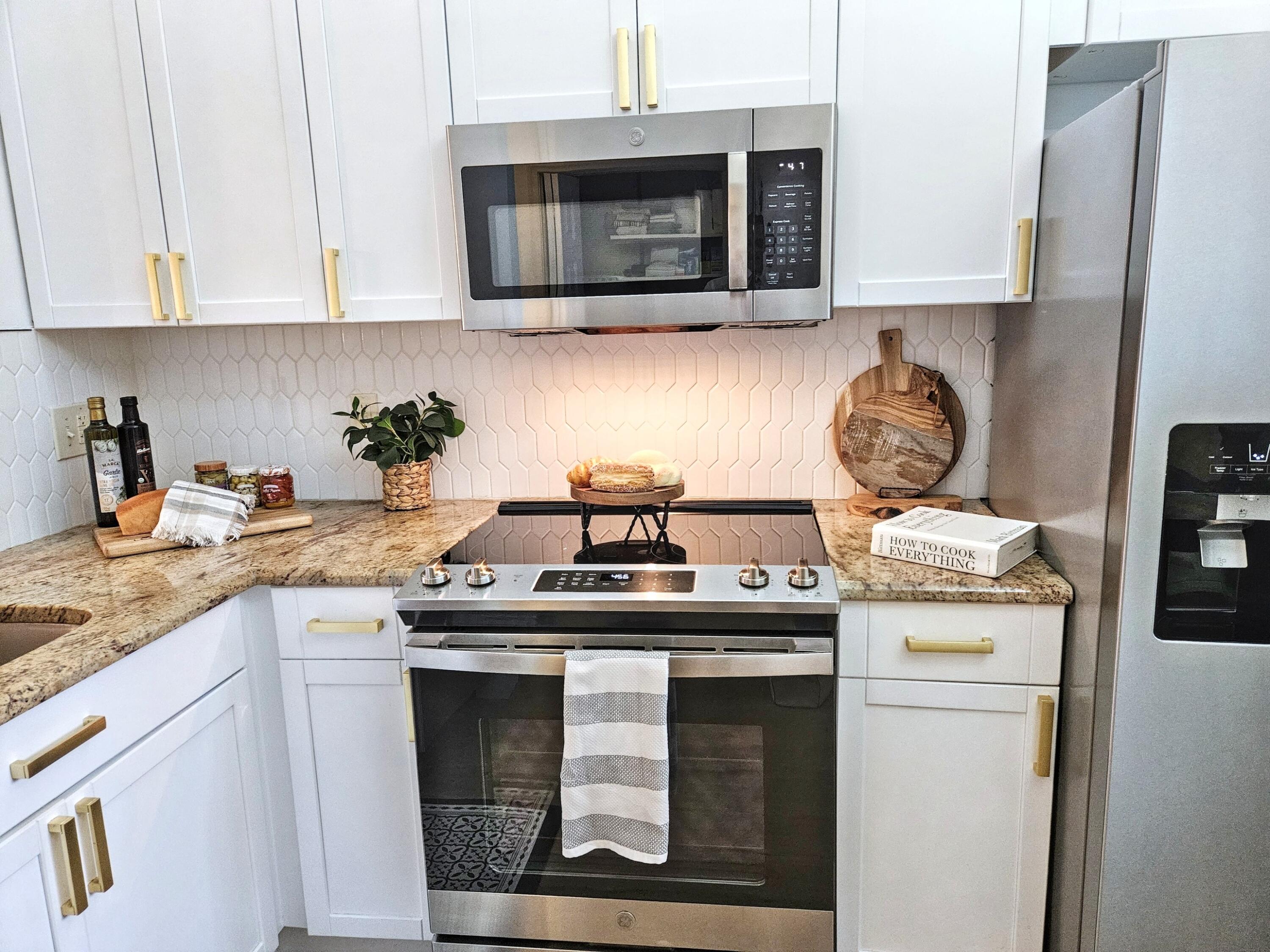 6530 North Ocean Boulevard, Unit 205 Ocean Ridge, FL 33435 - Photo 6 of 53 a kitchen with stainless steel appliances granite countertop a sink stove and microwave