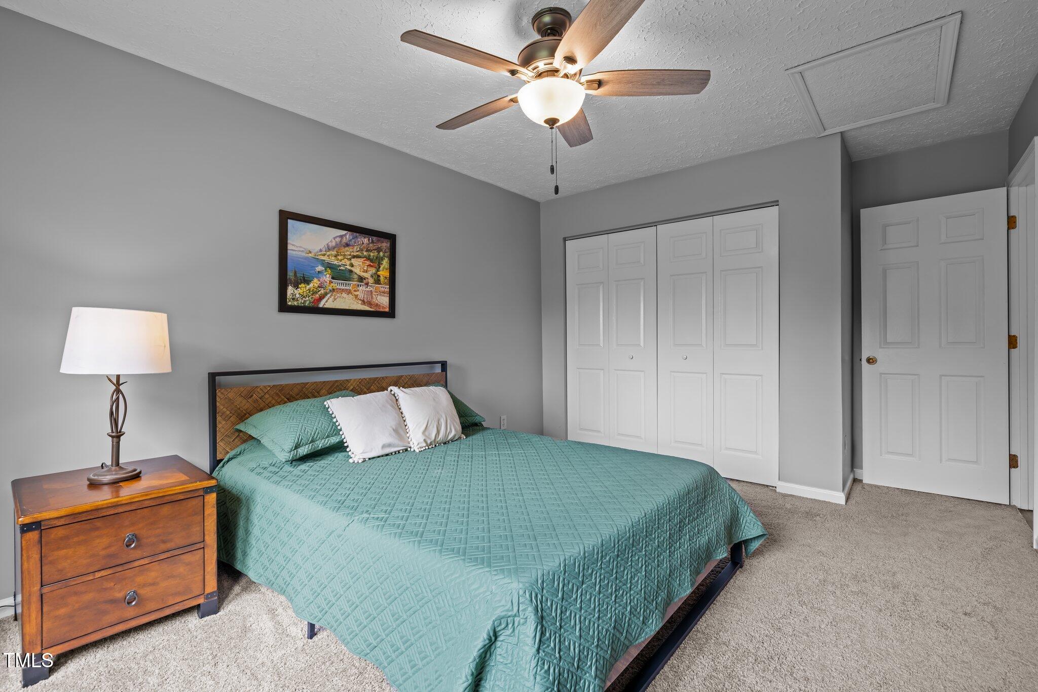 5801 Hadrian Drive Durham, NC 27703 - Photo 19 of 40 a bedroom with a bed and a lamp on the dresser