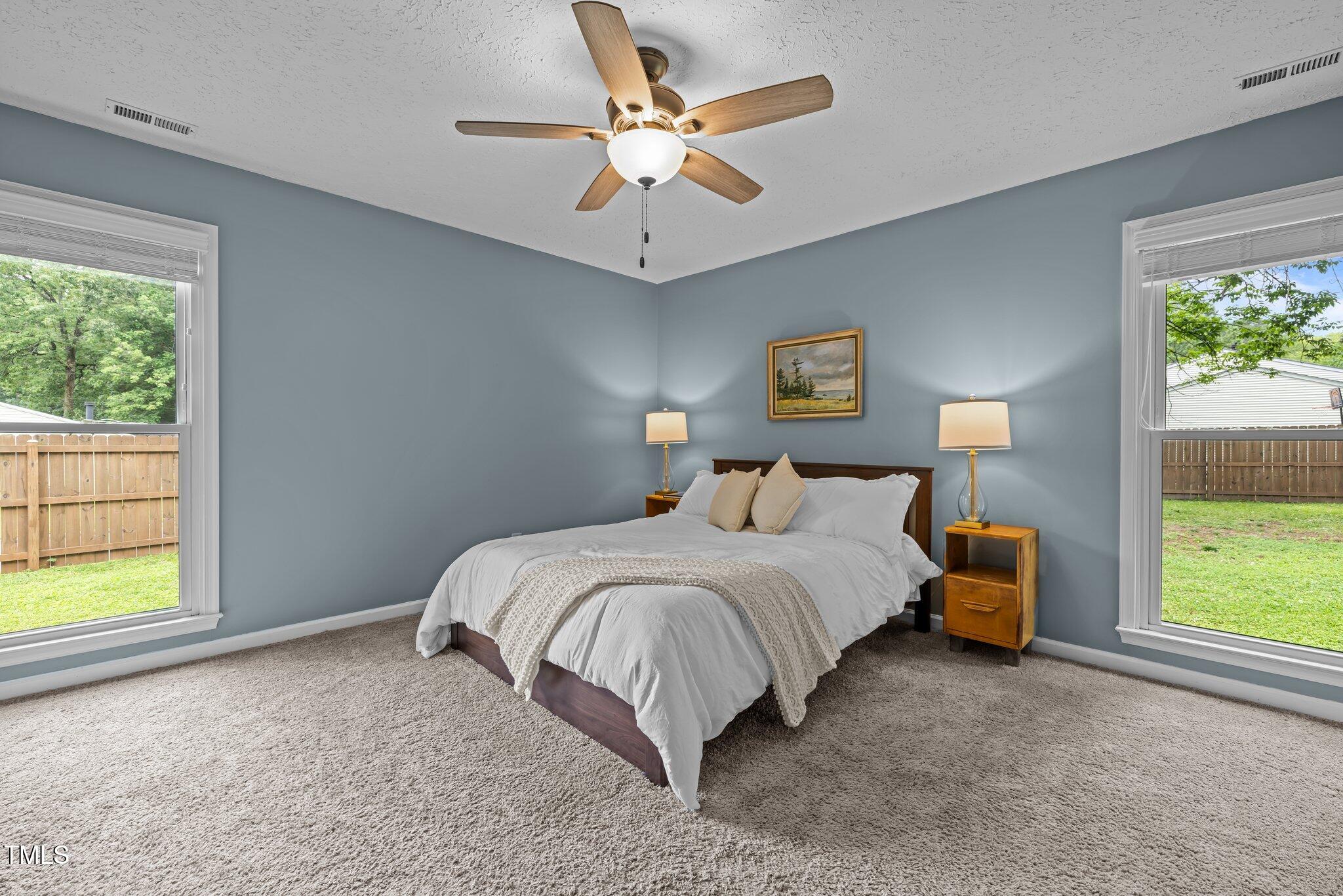 5801 Hadrian Drive Durham, NC 27703 - Photo 21 of 40 a bedroom with a bed and a large window