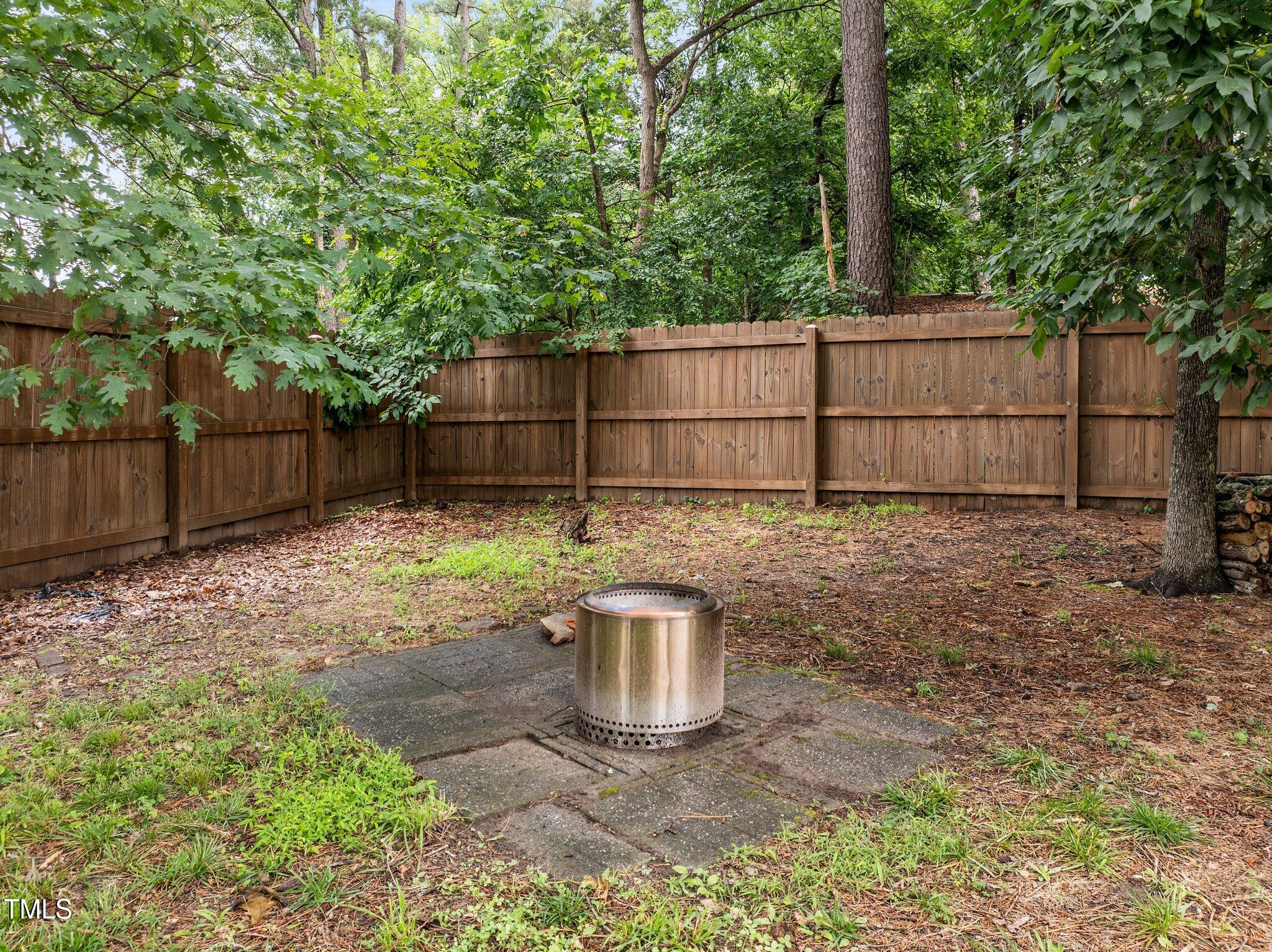 5801 Hadrian Drive Durham, NC 27703 - Photo 31 of 40 a view of a backyard with large trees and wooden fence