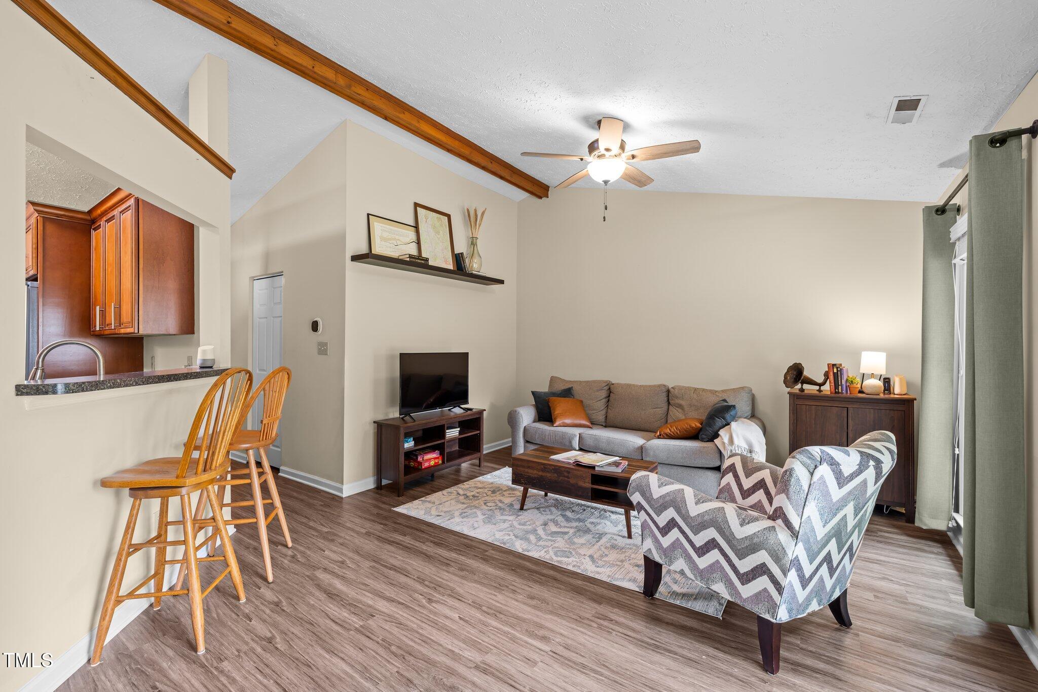 5801 Hadrian Drive Durham, NC 27703 - Photo 4 of 40 a living room with furniture a fireplace and a flat screen tv