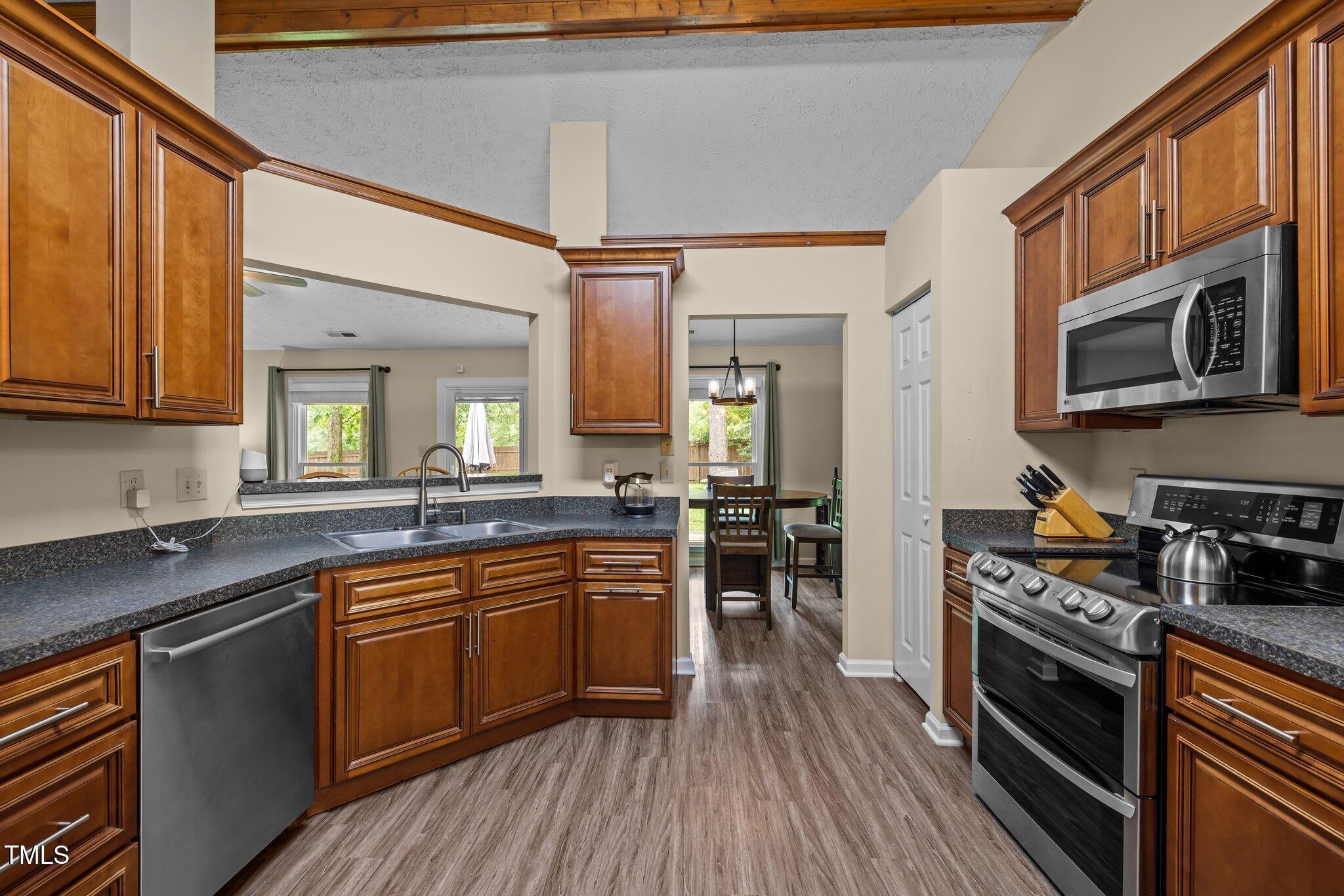 5801 Hadrian Drive Durham, NC 27703 - Photo 9 of 40 a kitchen with stainless steel appliances a stove sink microwave and cabinets