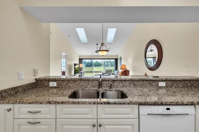 a spacious bathroom with a granite countertop sink a mirror a bathtub and shower