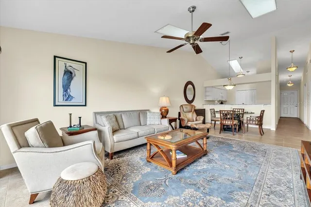 a living room with couch a flat screen tv and a floor to ceiling window