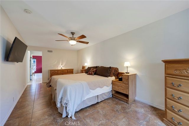 a spacious bedroom with a bed and a flat screen tv