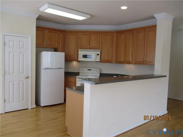 a kitchen with a refrigerator sink and cabinets