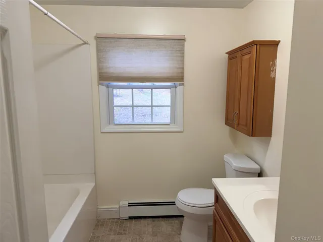 a white toilet sitting next to a bath tub