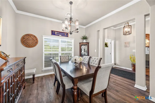 a view of a hallway with wooden floor and dining room