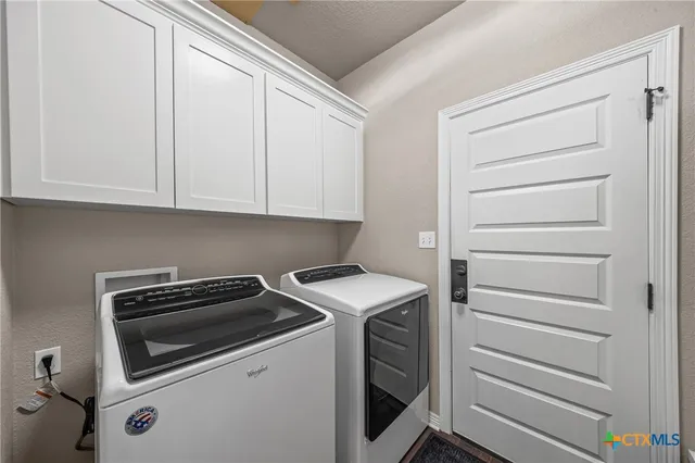 a spacious bedroom with a bed a couch and a chandelier