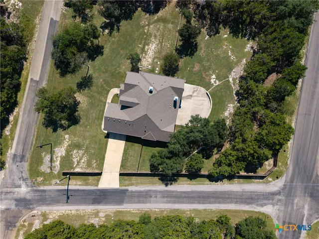 an aerial view of a house with a garden and lake view