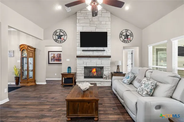 a large kitchen with stainless steel appliances kitchen island granite countertop a large center island a stove a refrigerator and a living room view