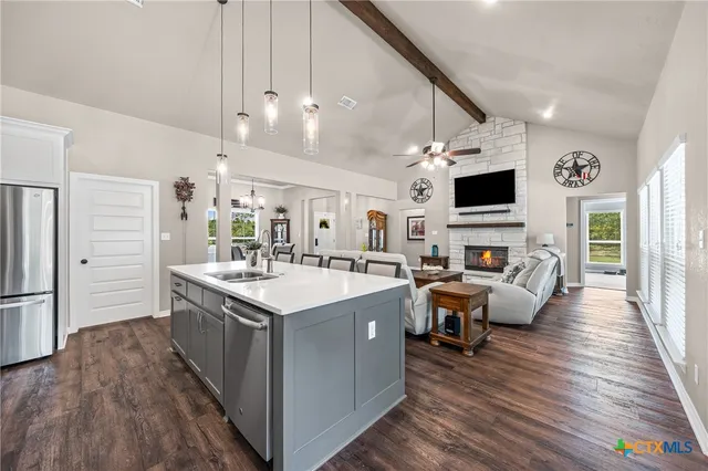 a kitchen with stainless steel appliances a stove a sink a refrigerator and cabinets