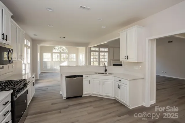 a large kitchen with stainless steel appliances granite countertop a stove and a sink