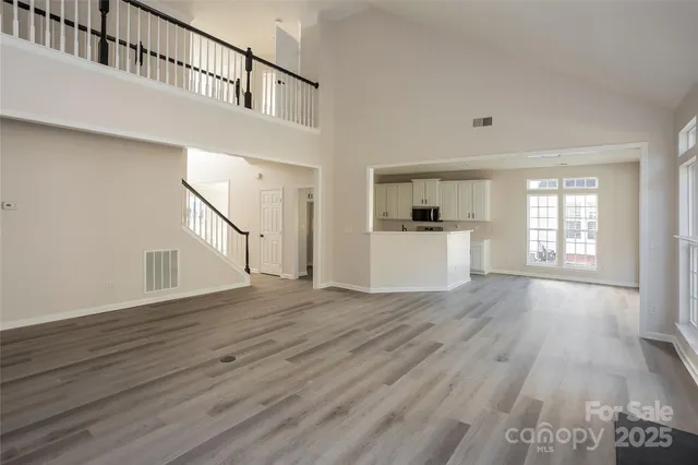 a view of empty room with wooden floor and windows