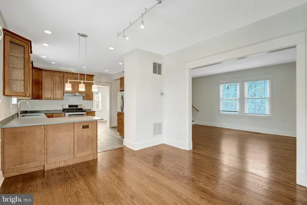 a view of kitchen with stainless steel appliances granite countertop a stove a sink and a refrigerator