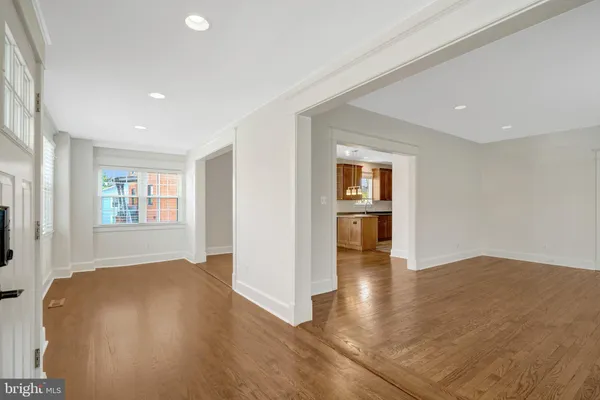 a view of an empty room with window and wooden floor