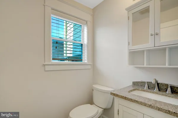 a bathroom with a granite countertop toilet and a sink