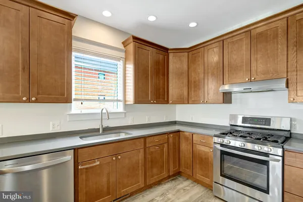 a kitchen with stainless steel appliances granite countertop a sink a stove and a microwave