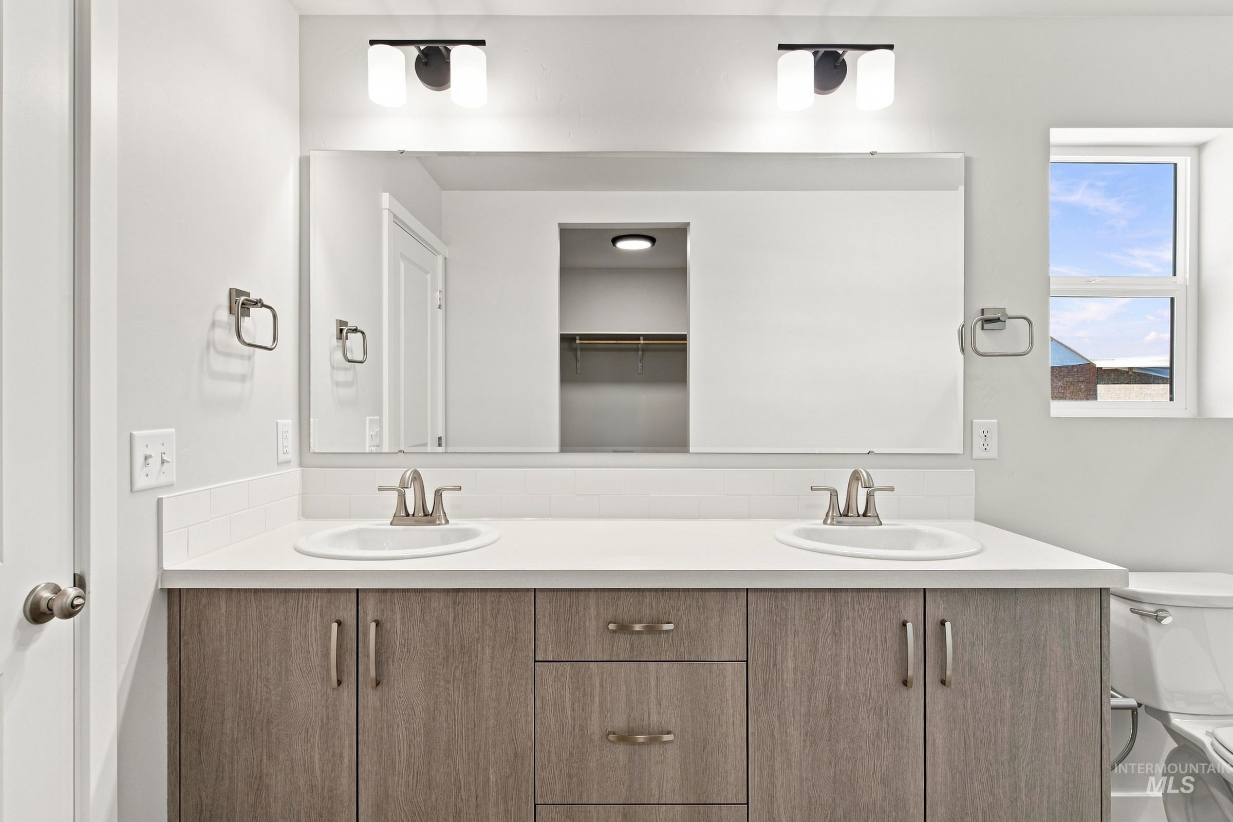 464 Merlin Court Middleton, ID 83644 - Photo 26 of 26 Double vanity with wood-finish cabinetry, white countertop, and dual undermount sinks
