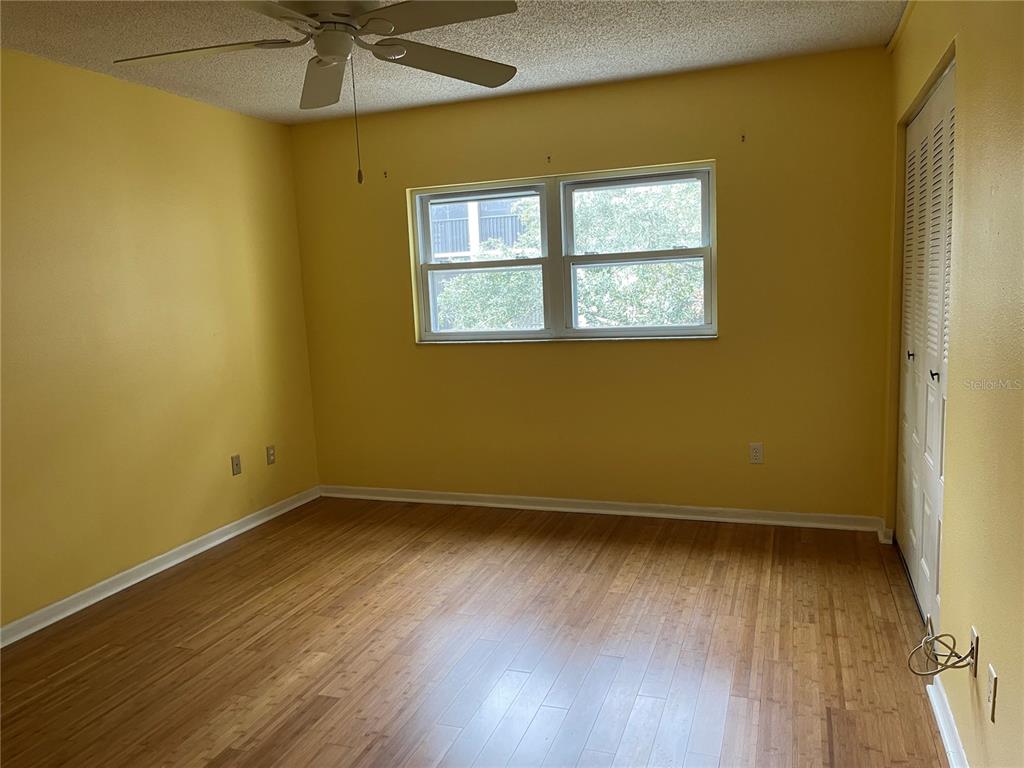 820 Virginia Street, Unit 207 Dunedin, FL 34698 - Photo 4 of 7 an empty room with a window and wooden floor