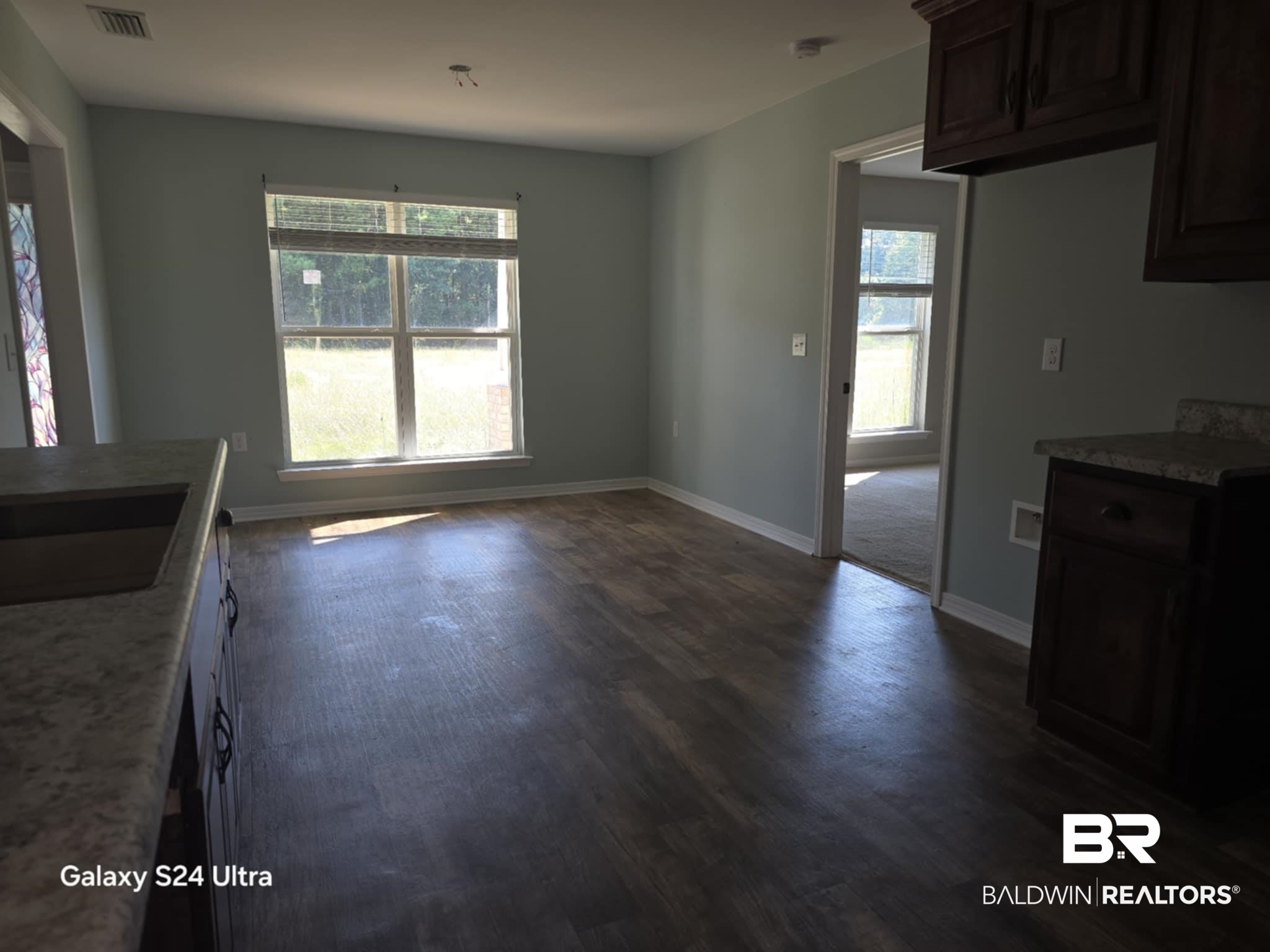 546 Wolf Log Road Flomaton, AL 36441 - Photo 4 of 15 Kitchen featuring dark brown cabinets, sink, dark hardwood / wood-style flooring, and dark stone counters