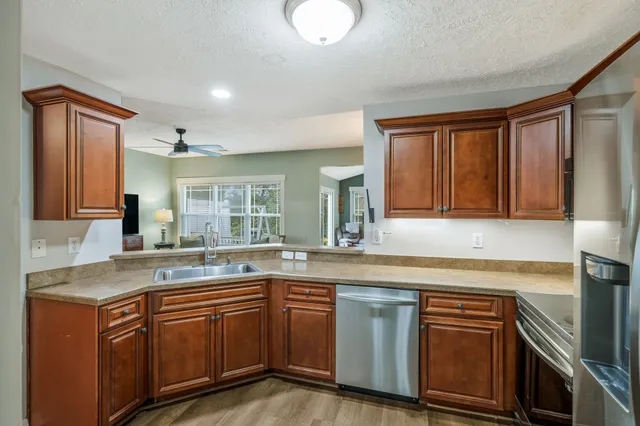 a kitchen with stainless steel appliances granite countertop a sink and cabinets with wooden floor