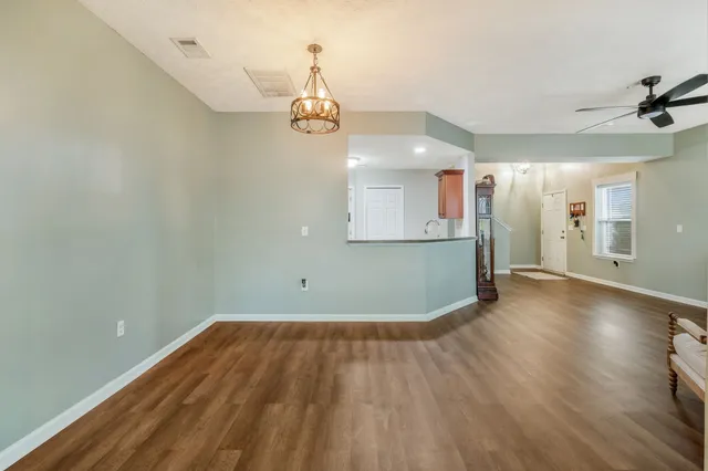 a view of empty room with wooden floor and window