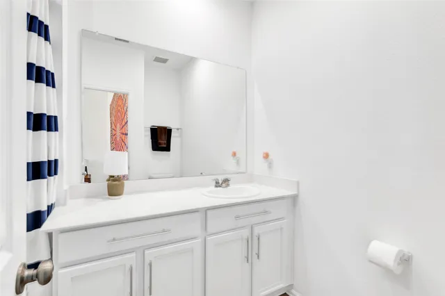 a bedroom with a bed table lamp and a window